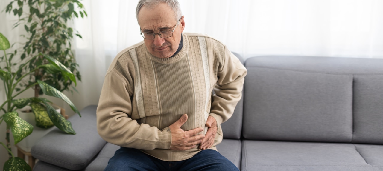 Older male grabbing abdomen in pain