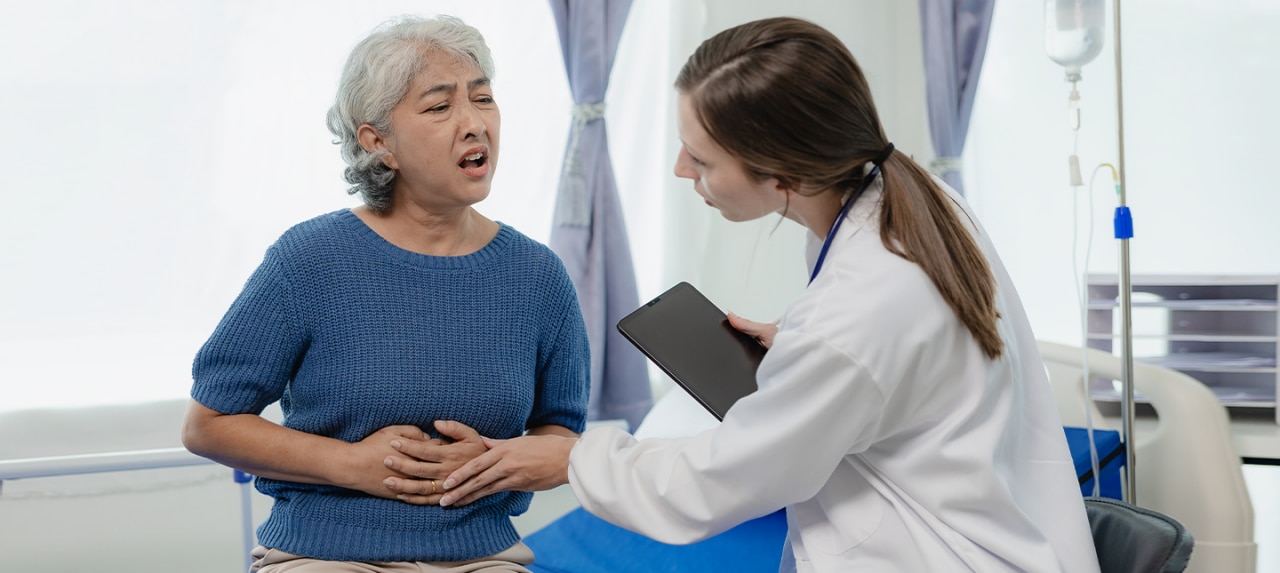 Elderly female patient getting a ventral hernia checked by a doctor